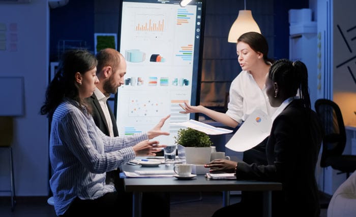 Business team in a strategy meeting with charts and presentations – SVDIGINET planning session in modern office